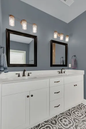 a bathroom with double vanity sink and a mirror