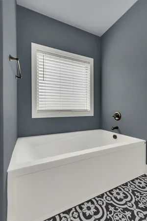 a bathroom with a bathtub and a window