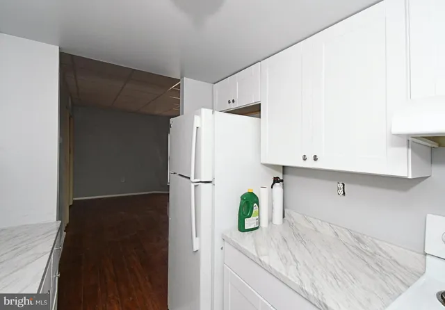 a kitchen with a refrigerator and a stove top oven