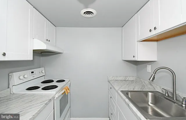 a kitchen with a sink a stove and cabinets