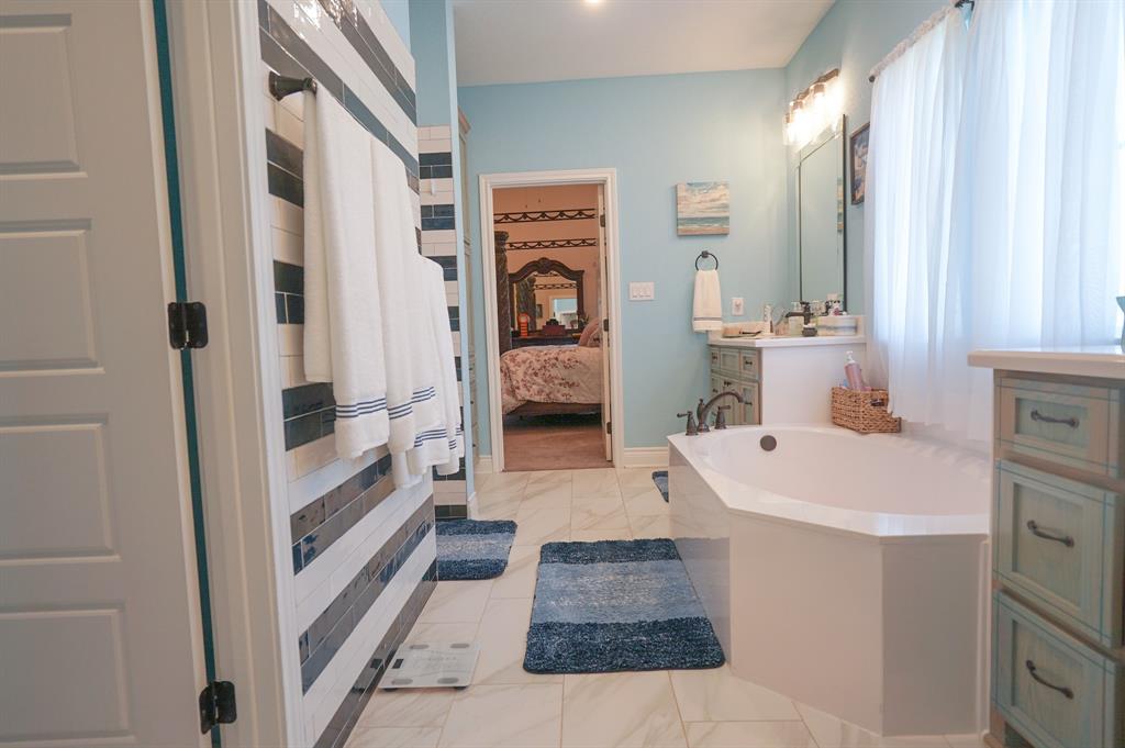 617 Mesquite Tree Road Waco, TX 76705 - Photo 24 of 39 a en suite bathroom with a sink a mirror and a shower