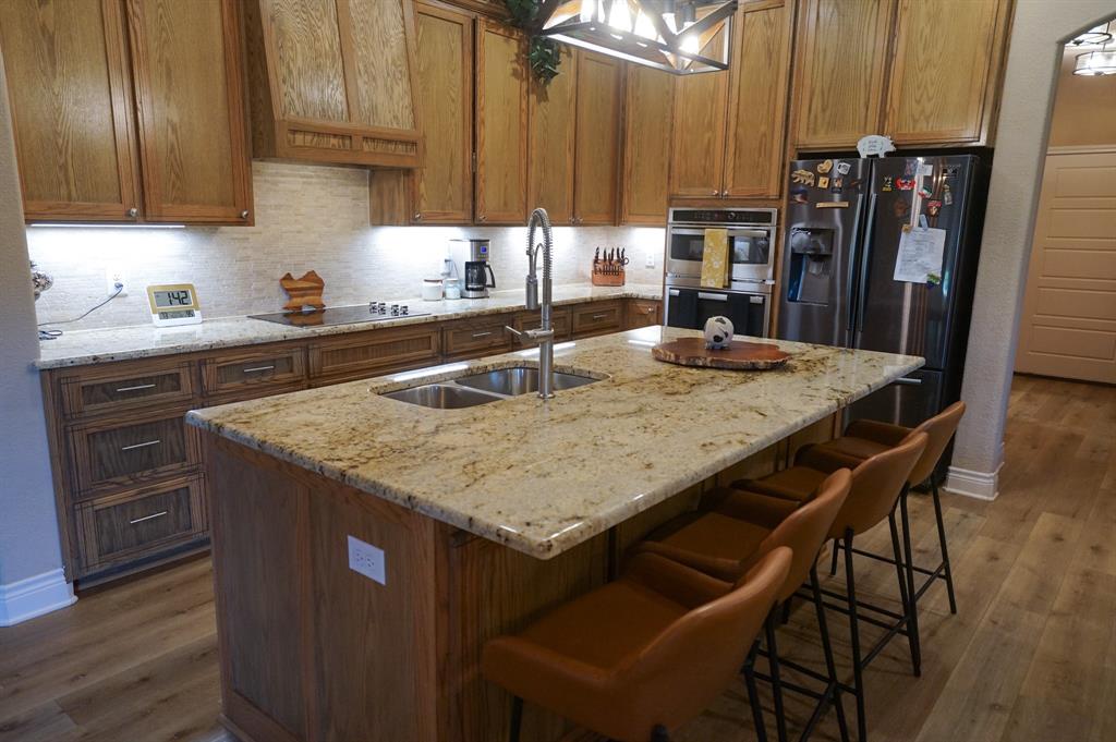 617 Mesquite Tree Road Waco, TX 76705 - Photo 9 of 39 a kitchen with granite countertop a table chairs stainless steel appliances and cabinets