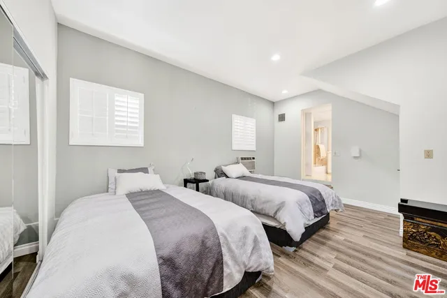 a bed room with two beds and a lamp