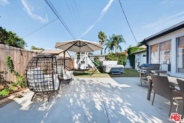 a view of a patio with table and chairs under an umbrella