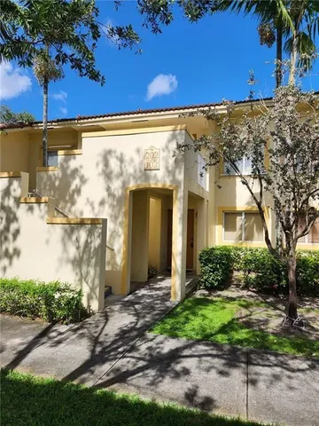 a view of a brick house with a large tree