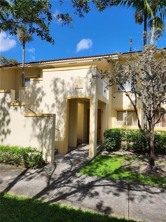 4775 Southwest 62nd Avenue, Unit 102 Davie, FL 33314 - Photo 1 of 6 a view of a brick house with a large tree