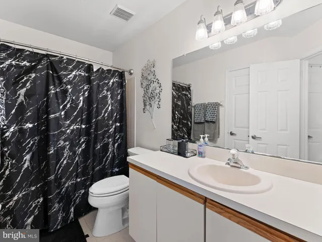 a bathroom with a sink vanity mirror and toilet