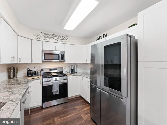 a kitchen with stainless steel appliances granite countertop a refrigerator stove and sink