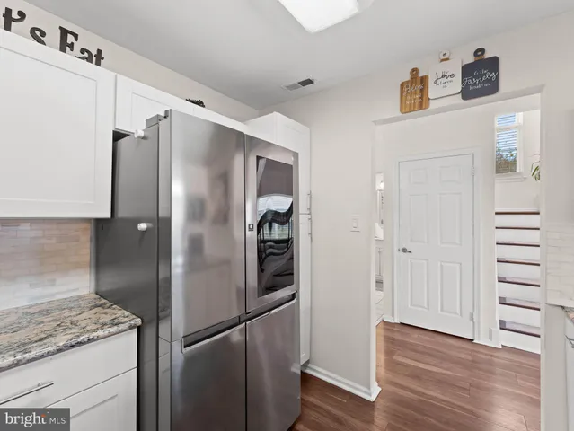 a metallic refrigerator freezer sitting in a kitchen