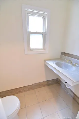a bathroom with a sink a toilet and a window