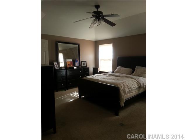 2742 Rustic Ridge Court, Unit 71 Rock Hill, SC 29730 - Photo 8 of 16 a bedroom with a bed and a chandelier