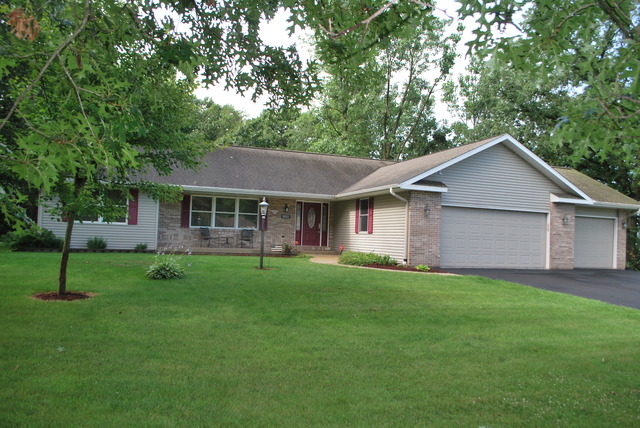 9217 Oak Ridge Drive Rochelle, IL 61068 - Photo 1 of 25 a front view of a house with a yard and trees