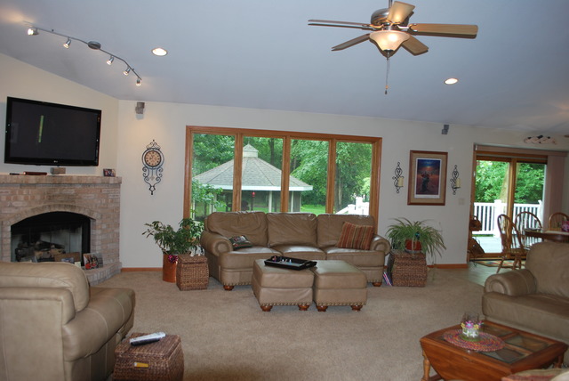 9217 Oak Ridge Drive Rochelle, IL 61068 - Photo 6 of 25 a living room with furniture a flat screen tv and a fireplace