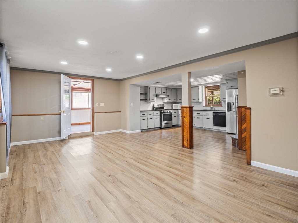 146 Lisbon Street Fall River, MA 02721 - Photo 17 of 42 an empty room with wooden floor and kitchen view