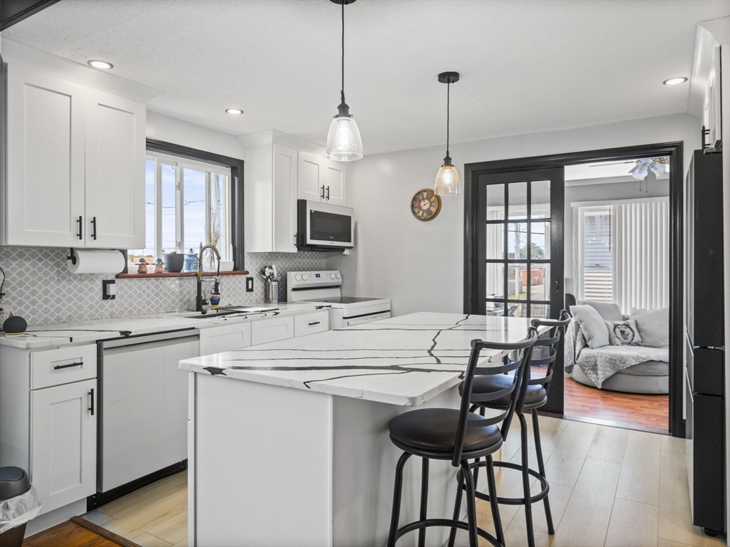 146 Lisbon Street Fall River, MA 02721 - Photo 6 of 42 a kitchen with center island table and chairs