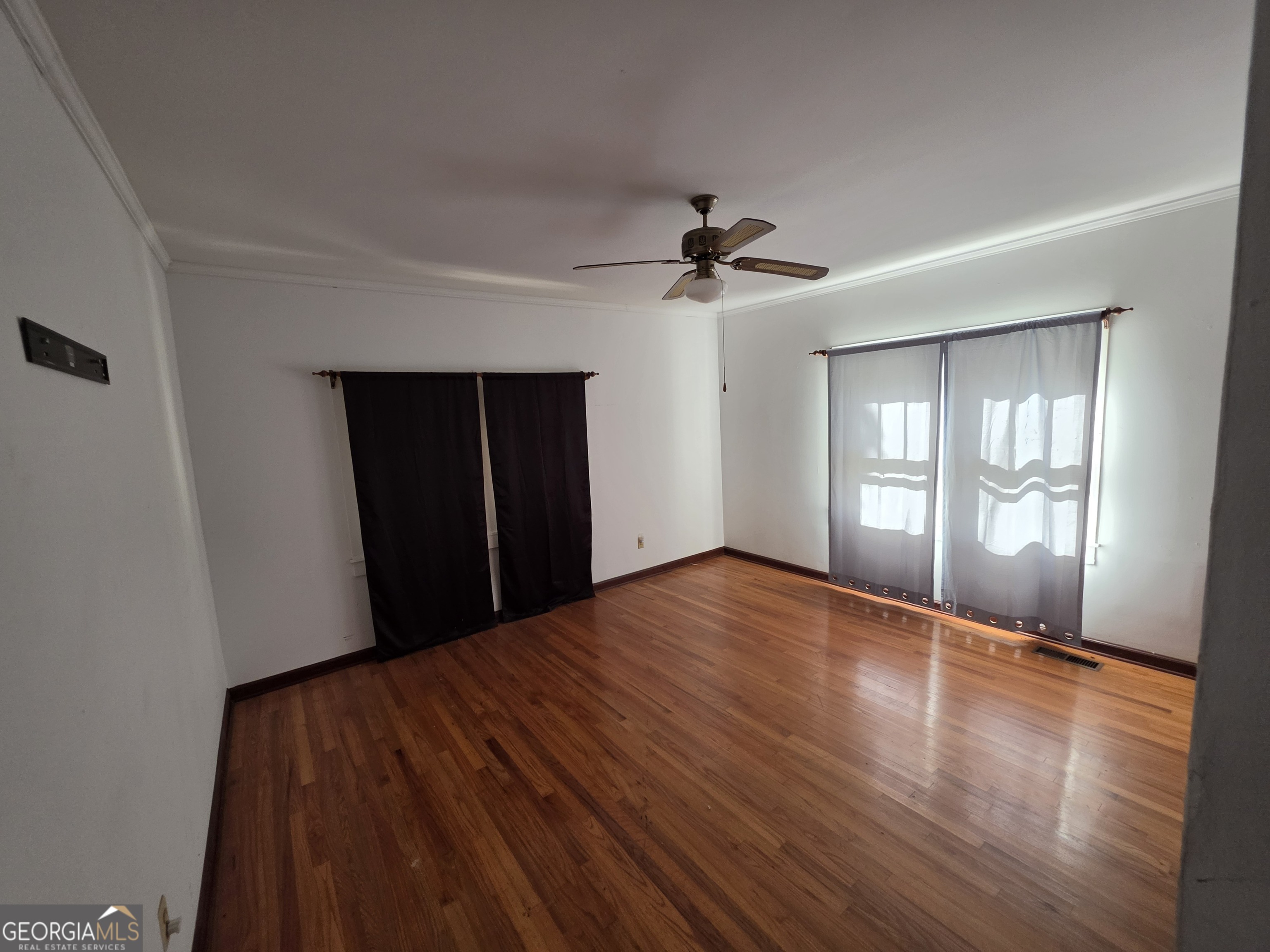 109 Springdale Drive Washington, GA 30673 - Photo 18 of 35 a view of an empty room with a window and wooden floor