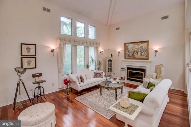 a living room with furniture a fireplace and a floor to ceiling window