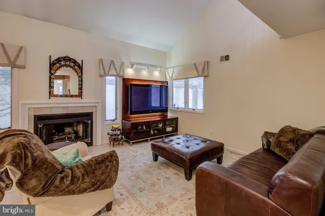 a living room with couches a fireplace and a flat screen tv