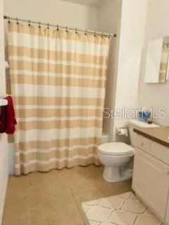 a bathroom with a toilet and a shower curtain