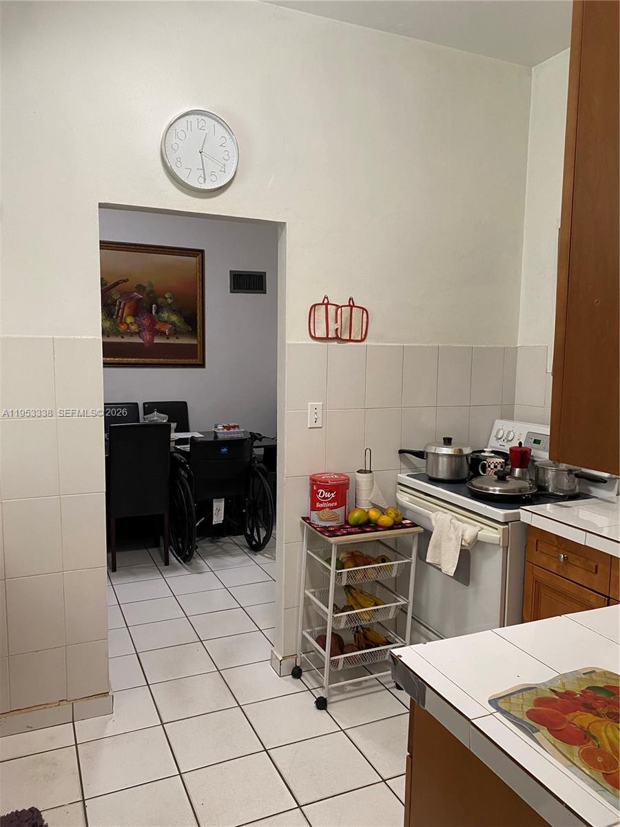1455 Northwest 112th Street Miami, FL 33167 - Photo 16 of 19 a kitchen with stainless steel appliances a stove a sink and a refrigerator