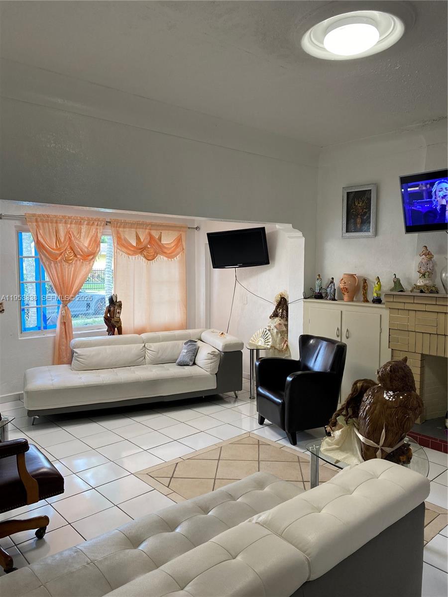 1455 Northwest 112th Street Miami, FL 33167 - Photo 7 of 19 a living room with furniture and a flat screen tv