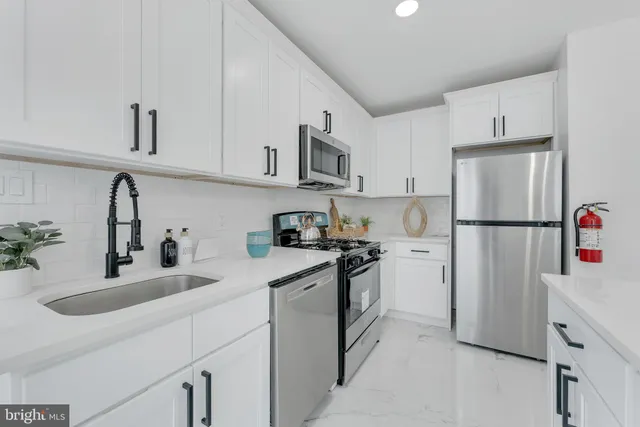 a kitchen with stainless steel appliances granite countertop white refrigerator stove top oven and sink