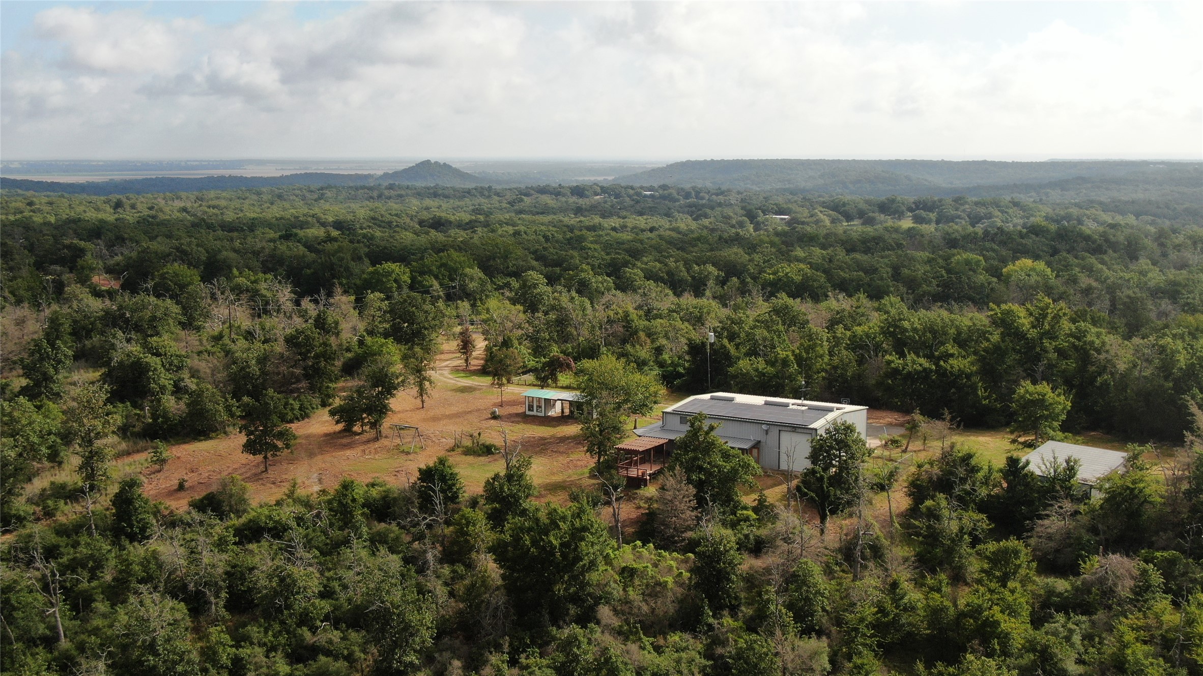 1004 22 Hills Road Gause, TX 77857 - Photo 4 of 37 Discover a private retreat nestled amidst dense woodlands with distant mountain views.