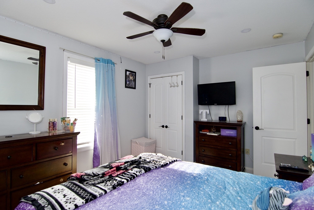 35 Anniversary Street Springfield, MA 01104 - Photo 25 of 37 a bedroom with a bed and a flat tv screen on dresser