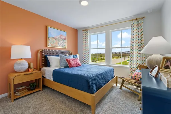 a bedroom with a bed and painting on the wall