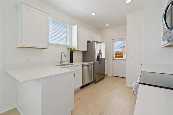a kitchen with a sink a refrigerator and cabinets