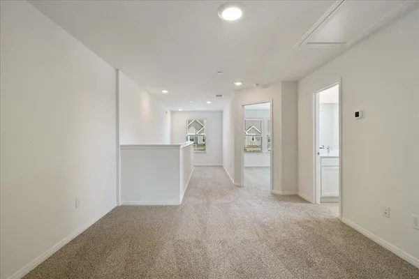 an empty room with a kitchen and a refrigerator