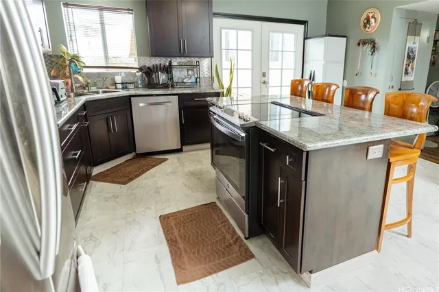 a kitchen with stainless steel appliances granite countertop a refrigerator a sink a stove and island