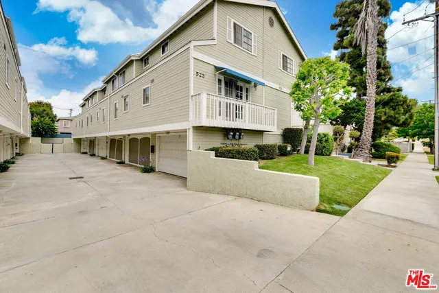 a view of a white house with a yard and plants