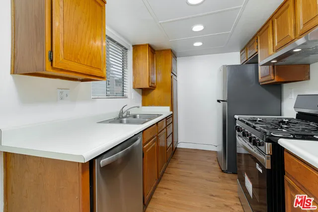 a kitchen with stainless steel appliances granite countertop a sink a stove and a refrigerator