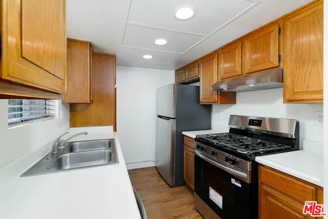 a kitchen with stainless steel appliances granite countertop a sink stove and refrigerator