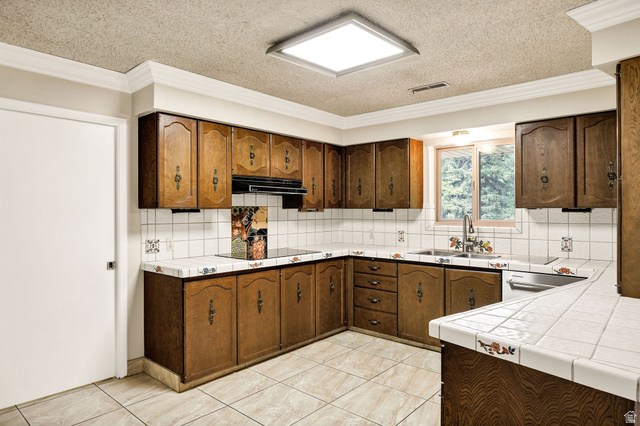 1365 Sumac Drive Logan, UT 84321 - Photo 18 of 66 Kitchen featuring extensive wood cabinetry, tile countertops, and a tile backsplash