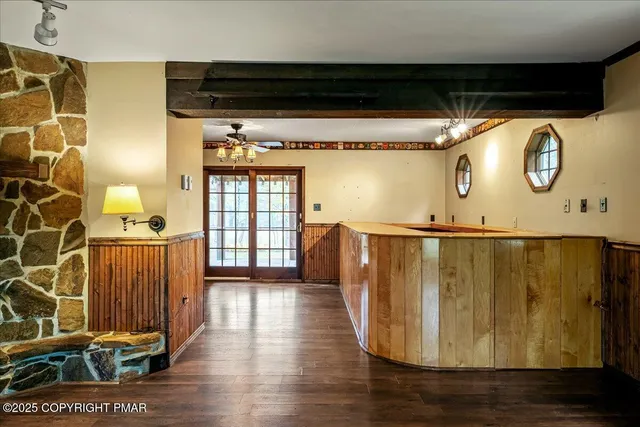 a view of an empty room with a window and a kitchen