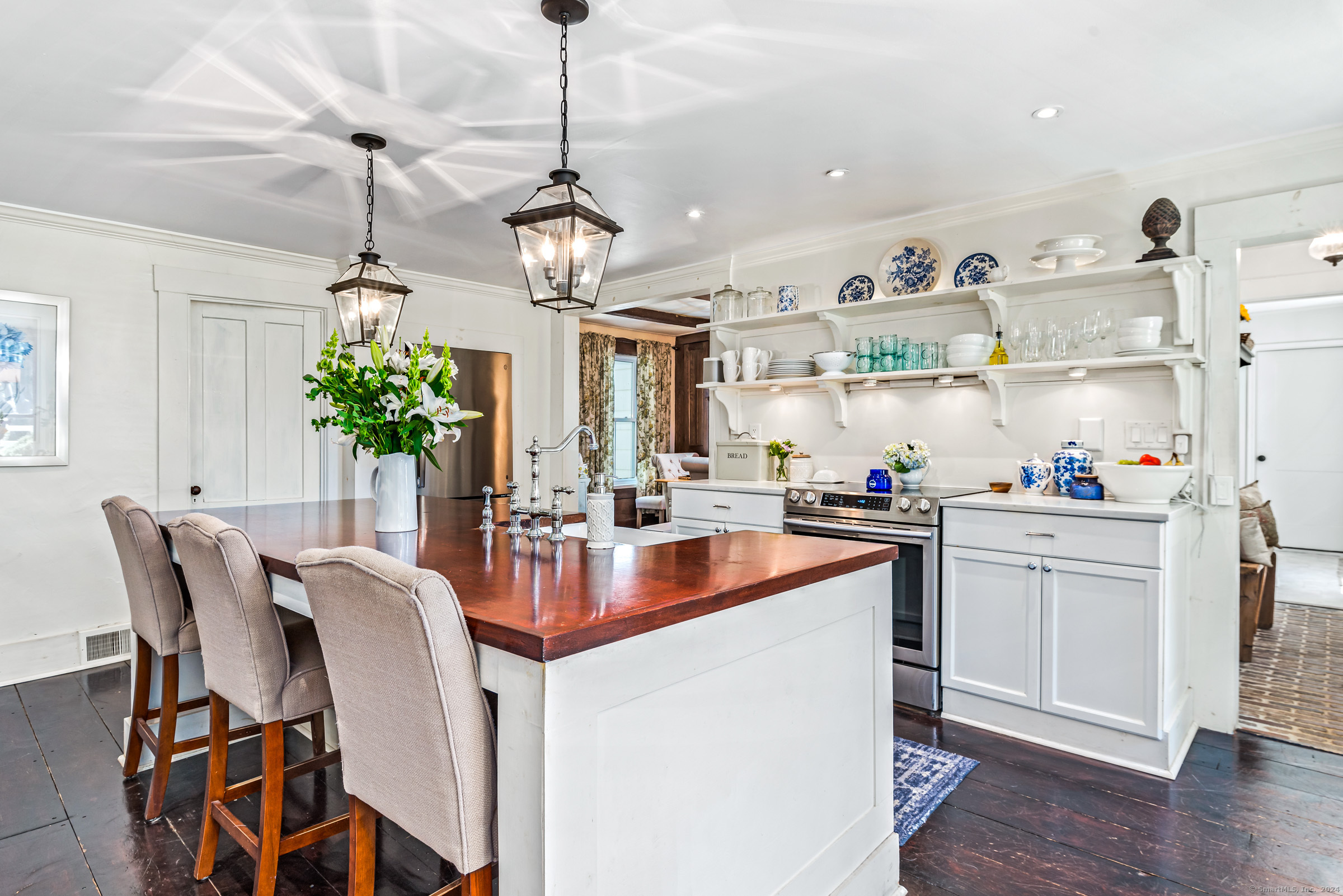 402 Perrin Road Woodstock, CT 06281 - Photo 12 of 40 a kitchen with stainless steel appliances kitchen island granite countertop a table chairs in it and wooden floors