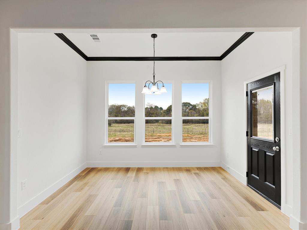 544 Shepherd Road Combine, TX 75159 - Photo 25 of 36 Unfurnished dining area featuring crown molding, suspended lighting, light wood-type flooring, and plenty of natural light