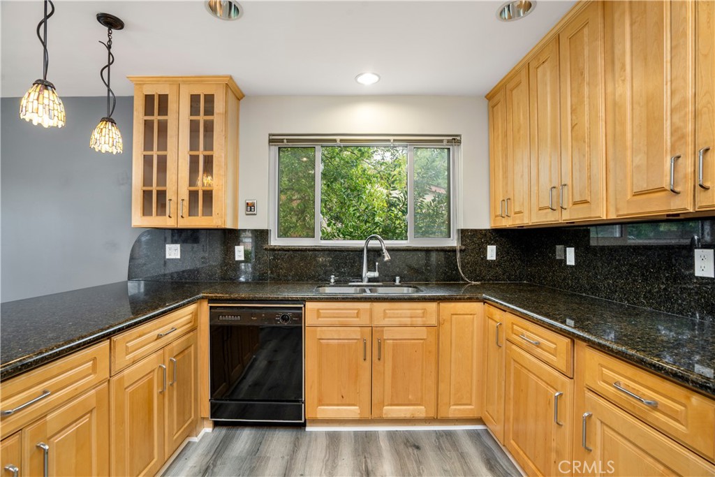 19738 Gresham Street Northridge, CA 91324 - Photo 5 of 35 a kitchen with granite countertop wooden cabinets stainless steel appliances a sink and a large window