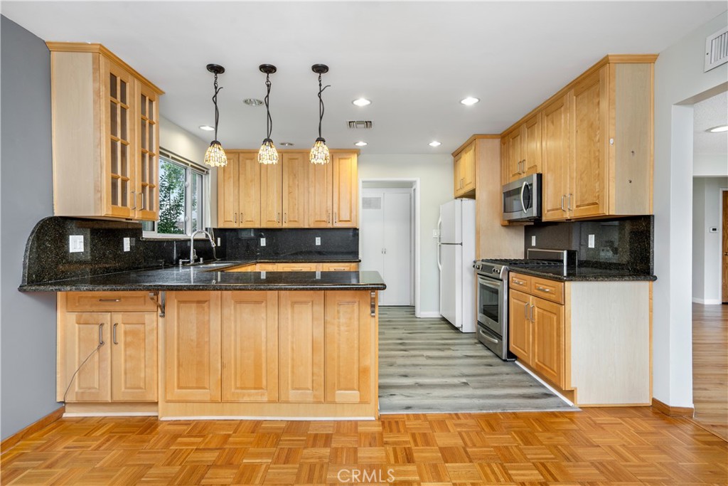 19738 Gresham Street Northridge, CA 91324 - Photo 7 of 35 a kitchen with stainless steel appliances granite countertop a stove a sink and a microwave
