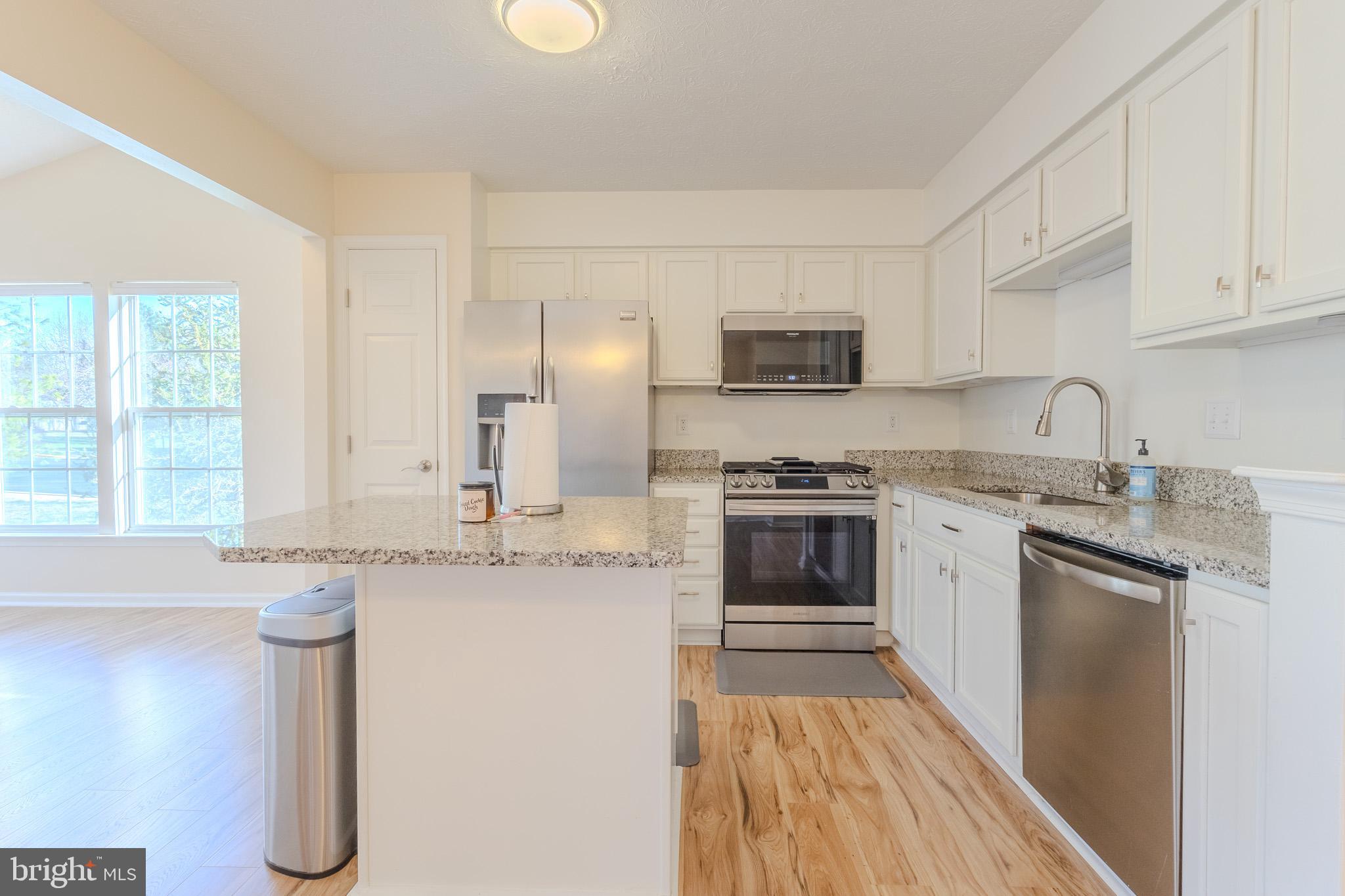 2437 High Brandy Way Odenton, MD 21113 - Photo 12 of 47 a kitchen with granite countertop a sink stove and refrigerator