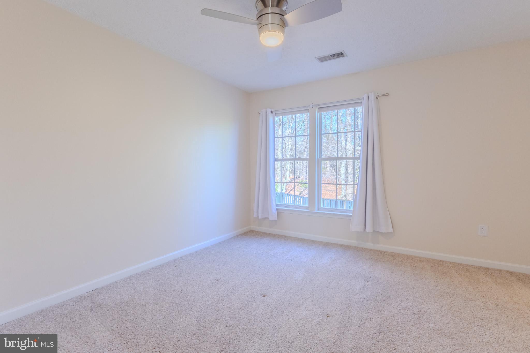 2437 High Brandy Way Odenton, MD 21113 - Photo 24 of 47 an empty room with a chandelier fan and windows