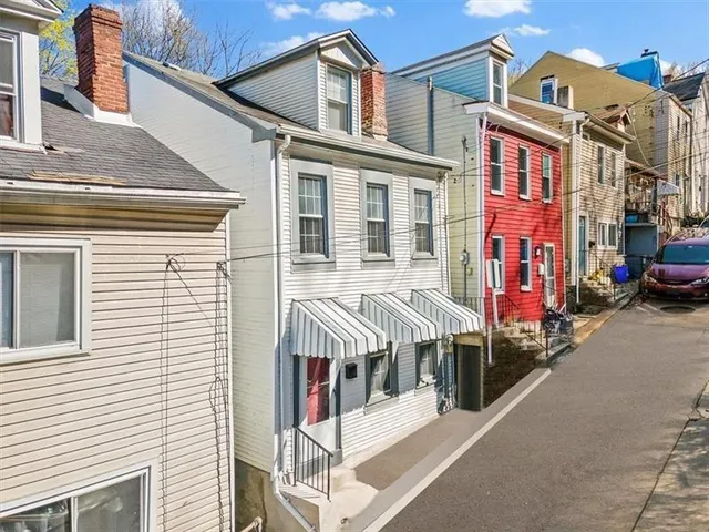 a view of a white building with many windows and a yard