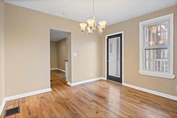 an empty room with chandelier fan and closet