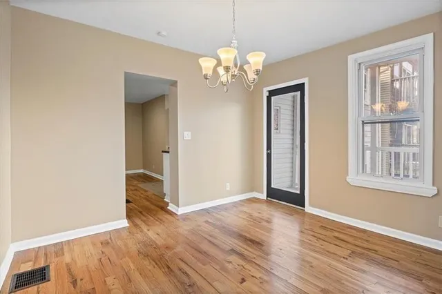 an empty room with chandelier fan and closet