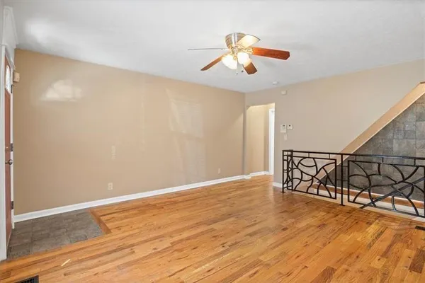 a view of an empty room with window and wooden floor