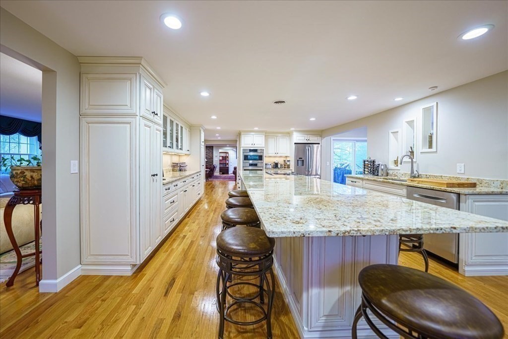 a view of a kitchen with kitchen island a counter top space a sink stainless steel appliances and cabinets