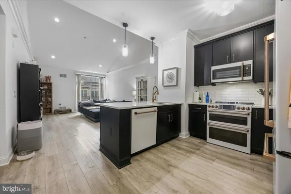 a kitchen with stainless steel appliances kitchen island granite countertop a stove a sink and a refrigerator