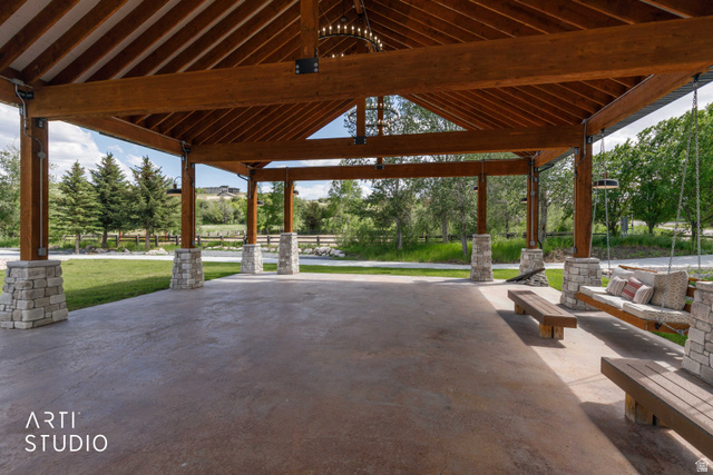 1188 South Old Trappers Loop Road Huntsville, UT 84317 - Photo 9 of 92 Expansive outdoor pavilion featuring a vaulted wood beam ceiling, stone-clad support columns, a concrete floor, and a suspended chandelier